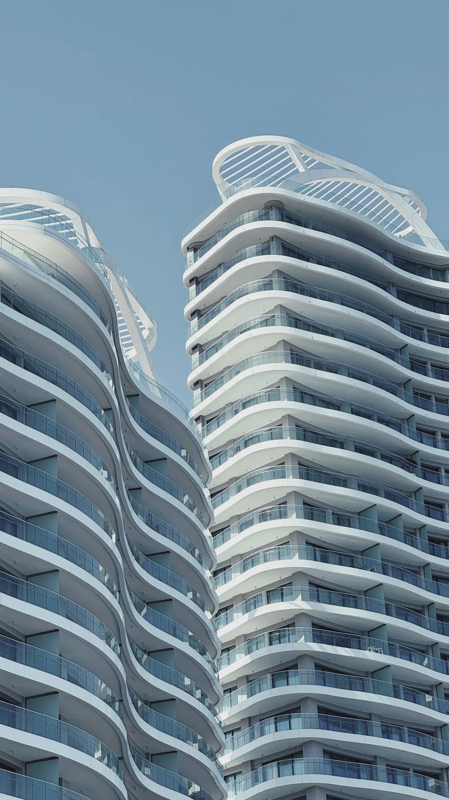 Two white high-rise apartment towers with curved balconies in Limassol, Cyprus
